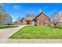 Well-maintained front lawn and mature trees enhance the curb appeal of this lovely home at 7854 Crooked Meadows Dr, Indianapolis, IN 46268