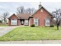 Charming brick home featuring a well-manicured lawn and a welcoming red front door at 7854 Crooked Meadows Dr, Indianapolis, IN 46268