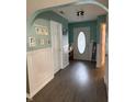 Inviting entryway featuring arched doorways, wainscoting, and a stylish front door with decorative glass at 7916 Begonia Ct, Indianapolis, IN 46113