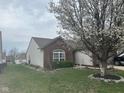 Attractive single-story home with lush lawn and beautiful flowering tree gracing the front yard at 7916 Begonia Ct, Indianapolis, IN 46113