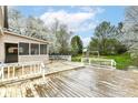 A spacious backyard shows an entertainment deck, play area and mature trees at 10516 Beacon Ln, Indianapolis, IN 46256