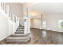 Open-concept living room features hardwood floors, staircase, and natural light at 10516 Beacon Ln, Indianapolis, IN 46256