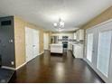 Modern kitchen with white cabinets, stainless steel appliances, and an island, open to the dining area at 10711 Regis Ct, Indianapolis, IN 46239