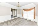 Bright living room featuring neutral walls, plush carpet, and a large window with elegant curtains at 10944 Echo Trl, Indianapolis, IN 46236