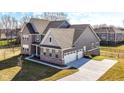 Beautiful new construction home with a spacious three-car garage and modern gray siding at 11392 Gammel Pl, Fishers, IN 46040