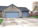 Attached two-car garage with brick facade and space for vehicles, complete with driveway and manicured yard at 1915 Barbie Ct, Franklin, IN 46131