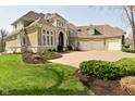 Well-maintained home featuring a sprawling lawn, mature landscaping, and an attached three-car garage at 2004 Caledonian Ct, Greenwood, IN 46143