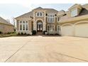 Elegant home with an arched entry, expansive driveway, three-car garage and manicured landscaping at 2004 Caledonian Ct, Greenwood, IN 46143
