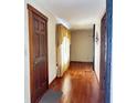 Hallway featuring hardwood floors, natural light, and classic wooden door frames at 204 W Berry St, Alexandria, IN 46001