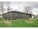 The exterior showcasing the home's brick finish, windows, and attached garage, surrounded by a well-maintained yard at 2134 Dawson St, Indianapolis, IN 46203
