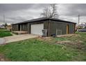 Exterior view of the home, featuring an attached garage, green lawn, and a functional side entry at 2134 Dawson St, Indianapolis, IN 46203