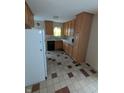 Traditional kitchen boasts wood cabinets, contrasting tiled floors, and modern black appliances at 2612 Mcleay Dr, Indianapolis, IN 46220