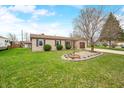 Charming brick home boasting a well-manicured lawn and landscaped garden beds under a bright, sunny sky at 301 Lancelot Dr, Franklin, IN 46131