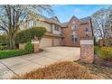 Stately brick home features a two-car garage, paved driveway, and mature landscaping with a lush green lawn at 328 Millridge Dr, Indianapolis, IN 46290