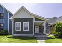 Charming home featuring a covered porch, gray siding and white trim and well-maintained front lawn at 337 E Minnesota St, Indianapolis, IN 46225