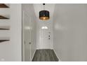 Bright hallway with vinyl flooring, light fixture, and access to various rooms in the house at 4744 Whirlaway Dr, Indianapolis, IN 46237