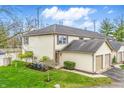 Back view of a well-maintained townhome featuring a lush green lawn and mature trees at 6059 S Bay Dr, Indianapolis, IN 46250