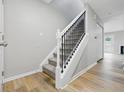 Inviting staircase with carpeted steps and modern railing, complemented by wood floors at 6059 S Bay Dr, Indianapolis, IN 46250
