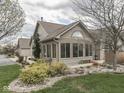 Rear exterior showcasing well-maintained landscaping and a sunroom addition with abundant natural light at 871 Gazebo Way, Greenwood, IN 46142