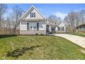 Beautifully landscaped home with a stone foundation, an attached garage, and manicured green grass at 11172 Cliffside Dr, Fortville, IN 46040