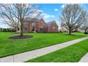 Handsome brick home with large front yard, mature trees, and a classic architectural design at 13225 Snow Owl Dr, Carmel, IN 46033