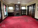 Cozy living room features a decorative fireplace, large windows, and vintage-style decor and original features at 1325 S Hackley St, Muncie, IN 47302