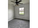 Cozy bedroom with gray carpet, painted brick wall, and modern ceiling fan at 1502 Saint John S Ct, Beech Grove, IN 46107