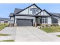 Inviting home featuring a two-car garage, gray and white exterior, and professionally landscaped front yard at 15755 Scher Dr, Westfield, IN 46074