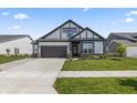 Charming home featuring gray and white colors, complemented by a landscaped front yard and a convenient two-car garage at 15755 Scher Dr, Westfield, IN 46074