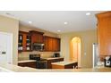 A kitchen view shows wood cabinets, an electric range, and granite countertops at 1630 Valdarno Dr, Greenwood, IN 46143