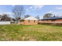 Expansive backyard showcasing the home's exterior, mature trees, and green lawn at 1700 N Tibbs Ave, Indianapolis, IN 46222