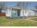 Inviting single-story home with covered porch, painted steps, and two turquoise chairs at 1957 N Colorado Ave, Indianapolis, IN 46218
