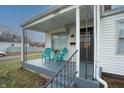 Front porch featuring a black front door, iron railing, and two turquoise chairs at 1957 N Colorado Ave, Indianapolis, IN 46218