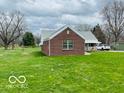 Back view of a brick house with a large, green lawn and mature trees at 2359 S County Road 1050 E, Indianapolis, IN 46231