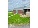 Quaint brick home with a covered porch and green lawn at 2359 S County Road 1050 E, Indianapolis, IN 46231