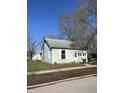 Charming light-blue home with a well-maintained lawn and mature trees on a clear, sunny day at 2627 Chase St, Anderson, IN 46016