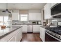 Modern kitchen featuring white cabinets, stainless steel appliances, granite countertops, and hardwood flooring at 3246 Fawn Cir, Brownsburg, IN 46112