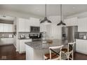 Open kitchen with center island, stainless steel appliances, white cabinets, and hardwood floors at 3246 Fawn Cir, Brownsburg, IN 46112