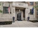 Building entrance featuring stone facade, decorative doors, and flagpoles at 355 E Ohio St # 310, Indianapolis, IN 46204