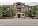 Brick building facade with stylish architecture, balconies, and manicured trees at 355 E Ohio St # 310, Indianapolis, IN 46204