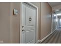 Hallway featuring a white door with decorative hardware and carpeted floors at 355 E Ohio St # 310, Indianapolis, IN 46204