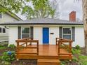 Welcoming home showcasing a bright blue door and a lovely wood porch at 3559 Carrollton Ave, Indianapolis, IN 46205