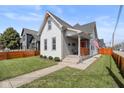 Inviting home showcasing a neat lawn and cozy porch, enhanced by a charming orange door and modern fence at 358 Terrace Ave, Indianapolis, IN 46225