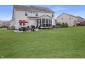 Spacious backyard with a well-maintained lawn, patio furniture and screened in porch at 4733 Mecklenburg Dr, Plainfield, IN 46168
