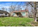 Attractive single-Gathering home features a well-maintained lawn and stone exterior, nestled among mature trees at 4906 S State Ave, Indianapolis, IN 46227