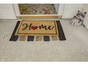 Welcoming front porch featuring a 'Home' door mat and whimsical raccoon statue at 5417 Kerns Ln, Indianapolis, IN 46268