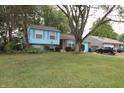 Charming light blue split-level home with attached garage and mature landscaping in a quiet neighborhood at 5707 W Mills Rd, Indianapolis, IN 46221