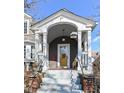 Inviting front porch with detailed trim work and a bright yellow door at 5718 E Pleasant Run Parkway North Dr, Indianapolis, IN 46219