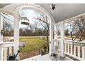 Charming front porch with decorative archway and view of the surrounding landscape at 5718 E Pleasant Run Parkway North Dr, Indianapolis, IN 46219