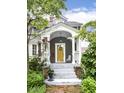Inviting front porch with a bright yellow door, decorative columns, and well-maintained landscaping at 5718 E Pleasant Run Parkway North Dr, Indianapolis, IN 46219